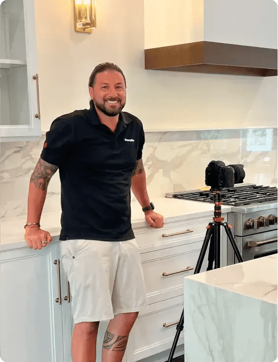 photographer Ronnie Walker standing in kitchen with camera and tripod
