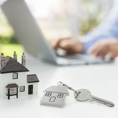 Real Estate Agent on Laptop with House Keychain